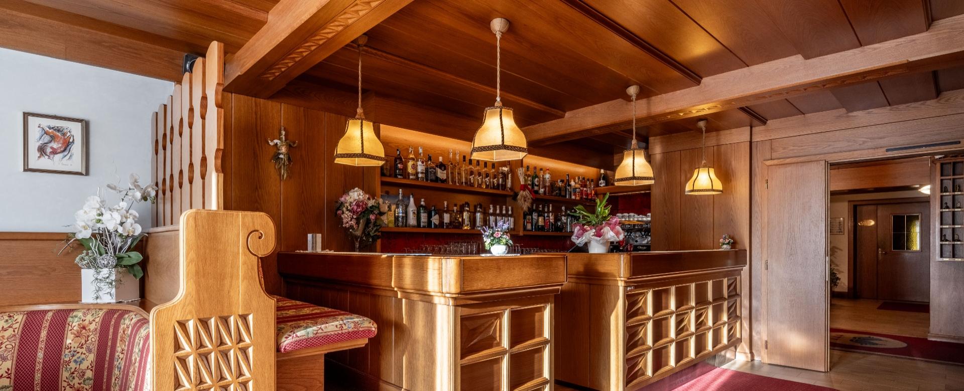 Cozy wooden bar with soft lighting and floral decorations.