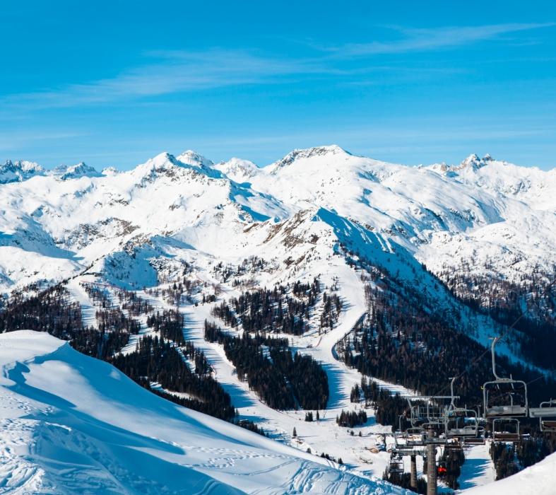 Snowy mountain landscape with ski slopes and chairlift.